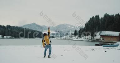 白雪皑皑的湖光山色带着一个大<strong>森林</strong>的年轻<strong>游客</strong>高兴地来到了他的目的地