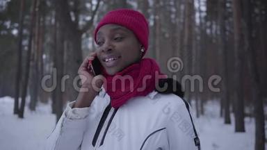 图为美国黑人少女在冬林中用手机近距离微笑。美女