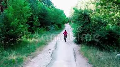 女孩骑着自行<strong>车</strong>，在一个晴朗的日子里被绿色的树木包围，<strong>俯视</strong>着。 在树林里骑自行<strong>车</strong>的女人
