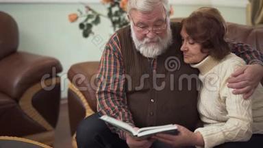 一对老夫妇看着一本大书或一张专辑，愉快地交谈，怀旧和欢笑