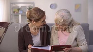 老年妇女在家庭相册中翻阅旧照片，回忆快乐