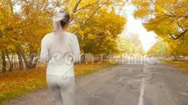美丽的<strong>女孩</strong>穿着<strong>运动服</strong>装从事户外运动，女人走在柏油路上，开始沿着秋天的自然奔跑，