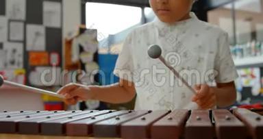 亚洲小学生在学校4k教室玩<strong>木琴</strong>的正面景色