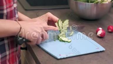 年轻家庭主妇用塑料板切黄瓜