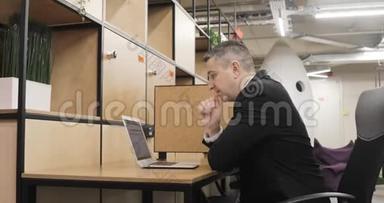 男士办公室经理正在现代同事中心工作笔记本电脑。