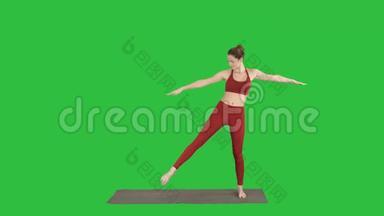 女人练习<strong>瑜伽</strong>，站在伸展的角度练习，Uttitaparsvakonasana在<strong>绿色</strong>屏幕上的姿势，Chroma