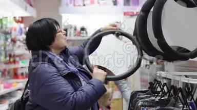 成熟的女人在选择一个软装饰的方向盘的汽车。