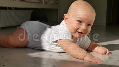 一个可爱的半岁婴儿躺在地板上，兴高采烈地笑着。 孩子敲着地板上的一条小溪