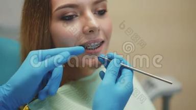 微笑的漂亮女孩正在牙科室接受治疗。 4K