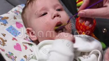 概念宝宝喂养，<strong>幼儿保育</strong>，首餐.. 母亲用勺子给孩子第一顿饭，勺子放在孩子的头上