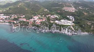 在希腊哈尔基迪基地区的旅游村和温泉设施下面有岩石的海上海岸鸟瞰图，无人机