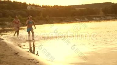 女孩们在沙滩上奔跑，在海滩上溅起水滴，笑着。 快乐自由的青少年