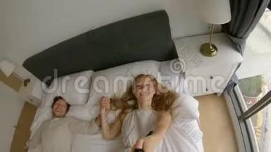 一对幸福的夫妇在床上摔倒的慢镜头。 旅行概念。 蜜月概念