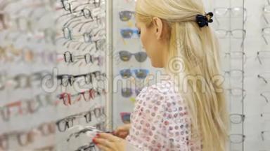 漂亮的女人正在<strong>眼镜店</strong>里挑选太阳眼镜