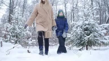 冬季乐趣和旅游理念。 母亲和儿子走在雪林里