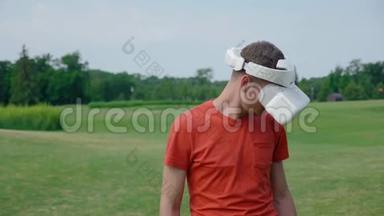 一个男人在公园里用VR耳机把头低下来