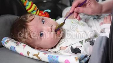 概念宝宝喂养，幼儿保育，首餐.. 母亲用勺子给孩子第一顿饭，勺子放在孩子的头上