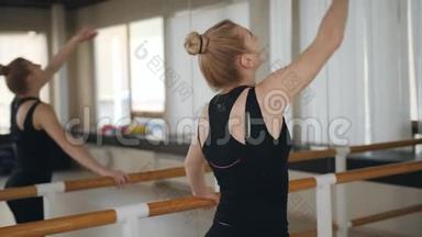 一名女舞蹈演员或芭蕾舞演员在舞厅的酒吧表演舞蹈练习。