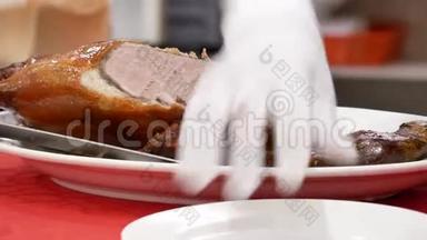中餐厅内厨师将烤鸭切成盘子的动作