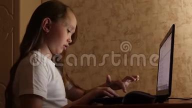 女孩通过拨打搜索查询和微笑在笔记本电脑上做作业。 网上电脑游戏