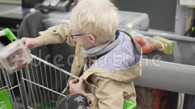 超市里的一个男孩从一个杂货篮里掏出东西