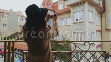 从后面看，特写镜头，穿着外套和帽子的斯特迪坎苗条的女人在城市里走来走去，拍了一张照片
