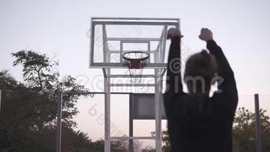 从后面的年轻女孩拍摄到<strong>篮球网</strong>的史泰迪卡姆镜头。 户外，背景树