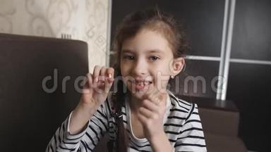 小女孩为掉下来的牙齿高兴。 小女孩的肖像出现在相机掉落的婴儿牙齿上。