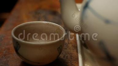 把红茶倒在咖啡馆的木桌上的小碗里