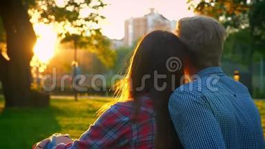 两个相爱的可爱的人紧紧地坐在令人惊叹的夏日公园里，阳光照耀着到处都是模糊的景色，可爱的。