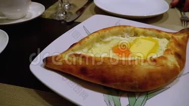 一家格鲁吉亚餐馆桌子上的阿贾里安·卡查普里。 带蛋黄的开放式面包派