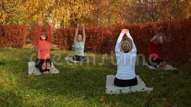 健身团体在公园垫子上练习瑜伽