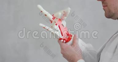 骨科医生对机器人假肢进行测试，试图移动手指，做手势。