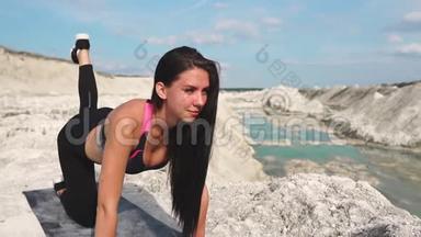 穿着黑色<strong>运动服</strong>的运动型黑发<strong>女孩</strong>在一个蓝水白垩沙场上训练。 狗`位置