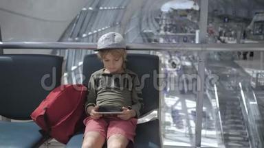 可爱的孩子在机场玩游戏，用智能手机看电影