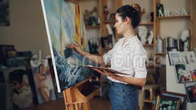 开朗的年轻女子艺术家是用油画画美丽的图画<strong>海洋风</strong>景，然后看杰作