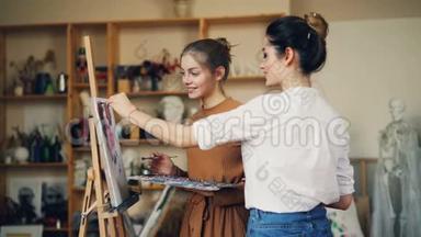 年轻的女美术老师和学生在创意工作室一起画画，上课时说话，微笑。 好吧
