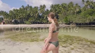 迷人的女人穿着比基尼在天堂海滩上清澈的<strong>海水</strong>上行走。 快乐的女人享受<strong>海水</strong>