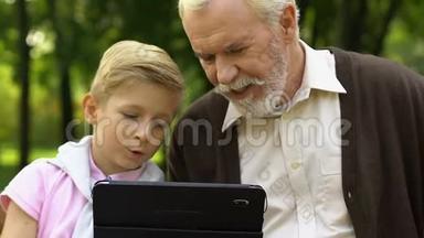 孙子在平板电脑上展示<strong>老爷爷</strong>的游戏，新的现代数字技术