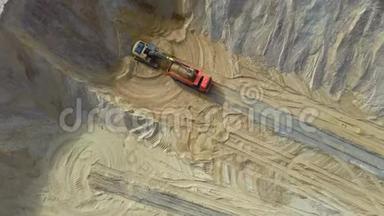 装载沙子进入卡车的空中视图。 一台<strong>重型</strong>机械-挖掘机和卡车正在采石场工作。