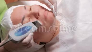 用电器清洁面部的化妆程序。 亚洲中年妇女躺在一个美女的医疗办公室里