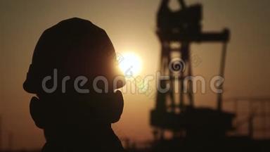 夕阳西下石油化工石油钻机泵工程师<strong>剪影</strong>。 <strong>工人</strong>站在...的背景上