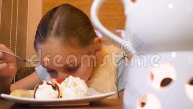 在餐厅的餐桌上吃冰淇淋<strong>甜点</strong>的亲密<strong>少女</strong>