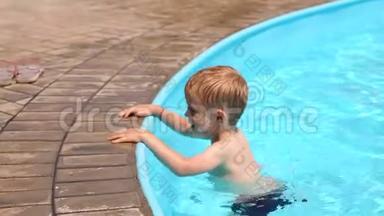 一个小男孩在暑假`孩子们的游泳池里玩耍和跳跃。