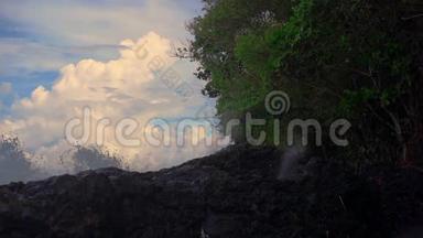 巴厘岛白沙滩附近的火山岩上自然形成的喷泉或间歇喷泉的超级慢镜头
