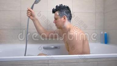 男人坐在浴缸里用洗发水洗头。