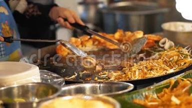 慢动作，厨师在热锅上烤着鱿鱼和章鱼。 一大道菜，配上美味的沙拉和油炸食品