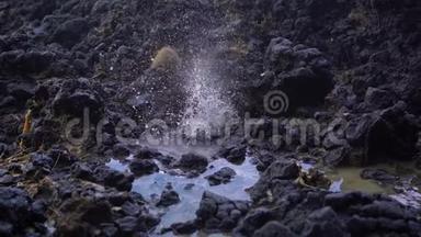 巴厘岛白沙滩附近的火山岩上自然形成的喷泉或间歇喷泉的超级慢镜头