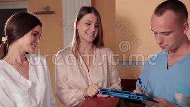 护士和医生穿着蓝色医用长袍，站在<strong>接待处</strong>咨询