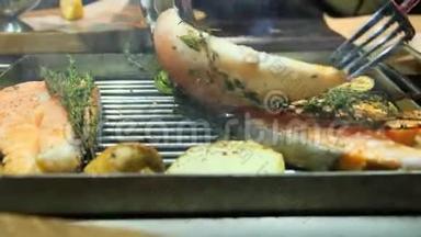烤鱼，烤三文鱼牛排，鸡肉，芳香香料和烤蔬菜牛排，用叉子翻转，靠近
